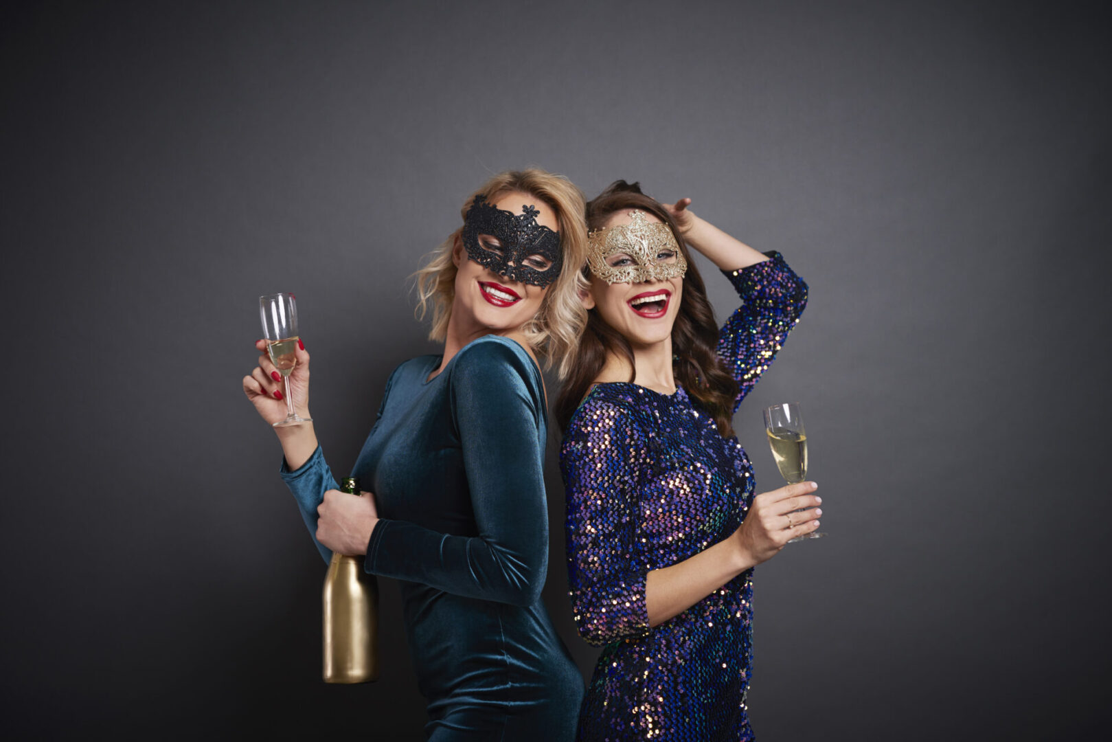 two women with masks and glasses of drink