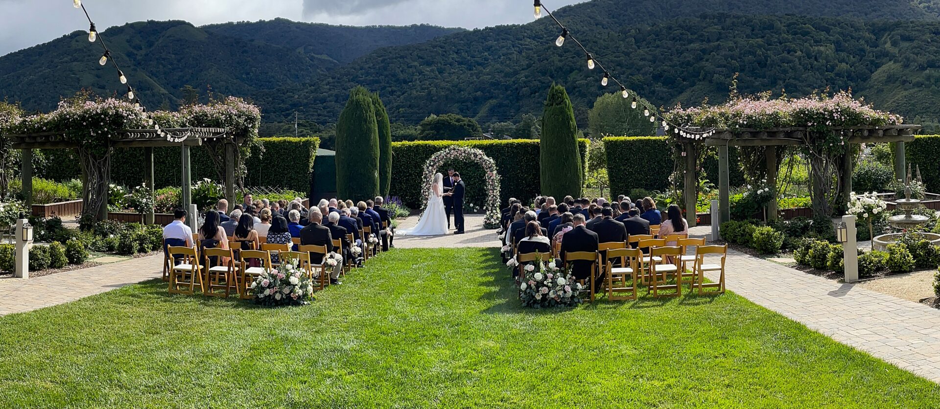 Outdoor wedding ceremony at Bernardus Lodge & Spa Rose Garden in Carmel Valley, California. Music provided by DJ Justin Warwick of DJ Enterprises Mobile Disc Jockey of Monterey. Wedding DJ FAQs | Wedding DJ Q&A